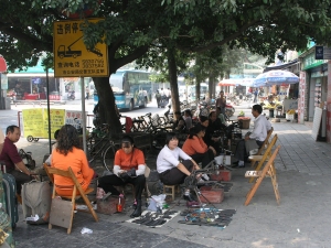 Shoe shiners outside the station in Guilin